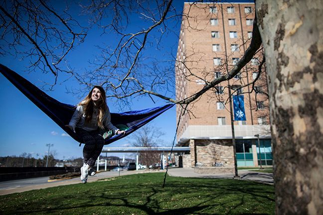 girl in a hammock in front of towers residence halls