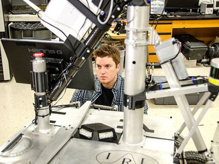 student in a lab looking at equipment